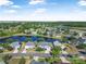 Stunning aerial view of homes surrounding a serene lake, lush greenery, and a beautiful sunny sky at 117 Hagge Dr, Daytona Beach, FL 32124