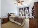 This bedroom features light blue walls, carpeted floors, a ceiling fan, and window with brown curtains at 117 Hagge Dr, Daytona Beach, FL 32124