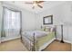 This bedroom offers white walls, carpeted floors, a window with white curtains, and a framed picture on the wall at 117 Hagge Dr, Daytona Beach, FL 32124