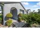 Home's covered arched entrance with lush tropical landscaping and decorative shrubbery at 117 Hagge Dr, Daytona Beach, FL 32124