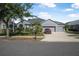 Charming single-story home with a well-manicured lawn, mature trees, and a three-car garage on a sunny day at 117 Hagge Dr, Daytona Beach, FL 32124