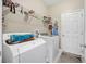 This laundry room features a washer and dryer, wire shelf, hangers, and a door at 117 Hagge Dr, Daytona Beach, FL 32124