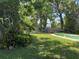 Lush backyard featuring mature trees, a storage shed, and a partially visible pool at 127 Mason Park Dr, Daytona Beach, FL 32117