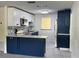 Modern kitchen featuring blue lower cabinets, white upper cabinets, and stainless steel appliances at 127 Mason Park Dr, Daytona Beach, FL 32117