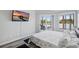 Bright bedroom boasts sliding glass doors, a picturesque lake view, and a modern mounted television at 129 Golden Eye Dr # C, Daytona Beach, FL 32119
