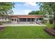 The backyard features a spacious patio, a ramp for accessibility, and a screen room for relaxing outdoors at 24538 Wildhog Rd, Astor, FL 32102