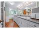 Spacious bathroom with double sinks, white cabinetry, a large mirror, wood-look flooring, and ample counter space at 24538 Wildhog Rd, Astor, FL 32102