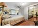 Bright bedroom with a ceiling fan, plush bedding, mirrored closet, and a large window providing ample natural light at 24538 Wildhog Rd, Astor, FL 32102