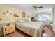 Inviting bedroom features a floral bedspread, ceiling fan, and traditional wall sconces providing a comfortable ambiance at 24538 Wildhog Rd, Astor, FL 32102