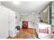 Functional laundry room with a modern red washer, ample storage cabinets, and bright natural lighting from a nearby window at 24538 Wildhog Rd, Astor, FL 32102