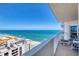 Balcony view of the ocean and coastline with outdoor chairs and a small table at 2937 S Atlantic Ave # 2001, Daytona Beach, FL 32118