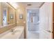 Bright bathroom with a single sink vanity, decorative art and octagon mirror outside of the doorway at 2937 S Atlantic Ave # 2001, Daytona Beach, FL 32118
