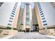 Grand entrance of condominium building with well-manicured landscaping and covered entry at 2937 S Atlantic Ave # 2001, Daytona Beach, FL 32118