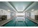 Clean indoor pool featuring tiled flooring, lounge chairs, and bright lighting at 2937 S Atlantic Ave # 2001, Daytona Beach, FL 32118