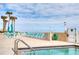 Outdoor pool deck with ocean view, featuring lounge chairs, tables, and umbrellas at 2937 S Atlantic Ave # 2001, Daytona Beach, FL 32118