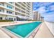 Outdoor pool with building view, surrounded by white railing and adjacent to the building at 2937 S Atlantic Ave # 2001, Daytona Beach, FL 32118