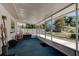 Enclosed sunroom with blue carpet, access to the yard, and plenty of natural light at 3119 Mango Tree Dr, Edgewater, FL 32141