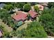 Aerial shot of a property with a pool, tile roof and mature trees offering privacy and shade at 3513 Kilgallen Ct, Ormond Beach, FL 32174