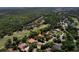 Aerial view of a home with a tile roof, pool, and golf course in a well-established neighborhood at 3513 Kilgallen Ct, Ormond Beach, FL 32174