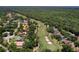 Overhead view of houses surrounded by trees with a golf course in the background at 3513 Kilgallen Ct, Ormond Beach, FL 32174