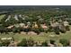 Aerial view of a home with a tile roof, pool, and golf course view in a lush, green neighborhood at 3513 Kilgallen Ct, Ormond Beach, FL 32174