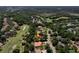 Aerial view of a home with a tile roof, pool, and golf course in a lush, green neighborhood at 3513 Kilgallen Ct, Ormond Beach, FL 32174