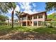 Exterior view of the back of the home, featuring a screened in porch and large windows at 3513 Kilgallen Ct, Ormond Beach, FL 32174