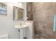 Elegant bathroom featuring a pedestal sink and a fully tiled walk-in shower with decorative tile accents at 3513 Kilgallen Ct, Ormond Beach, FL 32174