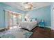 A bright bedroom with wood floors, a ceiling fan, and a sliding glass door to a screened porch at 3513 Kilgallen Ct, Ormond Beach, FL 32174