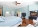 Spacious bedroom featuring wood floors, fireplace, ceiling fan, and calming blue walls at 3513 Kilgallen Ct, Ormond Beach, FL 32174