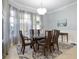Bright dining room with large windows, elegant curtains, and a glass-top dining table at 3513 Kilgallen Ct, Ormond Beach, FL 32174