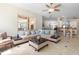Comfortable living room with large windows, ceiling fan, and an open layout leading to the kitchen at 3513 Kilgallen Ct, Ormond Beach, FL 32174