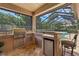 Outdoor kitchen with stainless steel appliances, granite countertops, and bar seating adjacent to the pool area at 3513 Kilgallen Ct, Ormond Beach, FL 32174