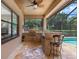 Covered outdoor kitchen featuring a grill, bar seating, and views of the screened-in pool area at 3513 Kilgallen Ct, Ormond Beach, FL 32174