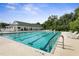 Large swimming pool with 6 marked lanes next to a clubhouse with many lawn chairs for residents at 3513 Kilgallen Ct, Ormond Beach, FL 32174