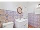 Bathroom features decorative tile, round mirror over vanity and a white toilet at 509 Park Dr, Daytona Beach, FL 32114