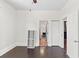 Bedroom with dark hardwood floors, ceiling fan, shoe rack and view to hallway and bathroom at 509 Park Dr, Daytona Beach, FL 32114