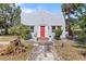 Charming single-story home featuring a stucco exterior, red door, and well-maintained landscaping at 509 Park Dr, Daytona Beach, FL 32114