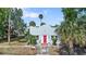 Charming light blue stucco home featuring a bright red front door and mature landscaping at 509 Park Dr, Daytona Beach, FL 32114