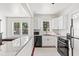 Kitchen featuring white cabinets, subway tile backsplash, granite countertops, and stainless appliances at 509 Park Dr, Daytona Beach, FL 32114