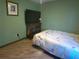 Bedroom with a floral patterned bedspread, hardwood floors, and a mounted television at 601 E Tall Pine Ter, Deland, FL 32724