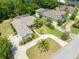 Aerial view of a home with landscaping, a driveway, green lawn, and mature trees at 69 Coquina Ridge Way, Ormond Beach, FL 32174