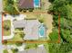 An aerial view showcasing the home, screen enclosed pool, lush greenery, and well-maintained yard at 69 Coquina Ridge Way, Ormond Beach, FL 32174