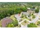 An aerial view of a home featuring a lush landscape and a screen-enclosed pool at 69 Coquina Ridge Way, Ormond Beach, FL 32174