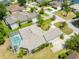 An aerial view of a charming home with a screened-in pool and well-maintained lawn and landscaping at 69 Coquina Ridge Way, Ormond Beach, FL 32174