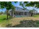 View of the backyard featuring an enclosed pool, landscaping, and an architectural style home at 69 Coquina Ridge Way, Ormond Beach, FL 32174