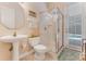 Bathroom with a pedestal sink, glass-enclosed shower, and a door to the pool deck at 69 Coquina Ridge Way, Ormond Beach, FL 32174