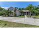 Charming single-Gathering home with mature landscaping, palm trees, and a driveway at 69 Coquina Ridge Way, Ormond Beach, FL 32174