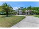 Beautiful single-Gathering home featuring a long driveway and mature landscaping, including palm trees at 69 Coquina Ridge Way, Ormond Beach, FL 32174
