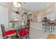 Kitchen with dining area featuring tiled floors, white cabinets, and decorative plant shelves at 69 Coquina Ridge Way, Ormond Beach, FL 32174